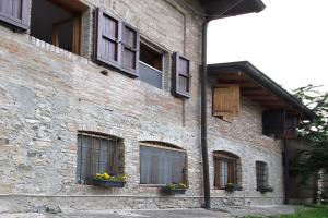 a brick building with windows and flowers on it at LA MAESTA' in Langhirano