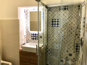 a bathroom with a shower with a sink and a mirror at Petit Maison Jeranto in Nerano +16 photos