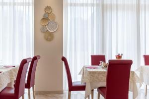 a dining room with a table with red chairs at Hotel Tiffany in Rimini