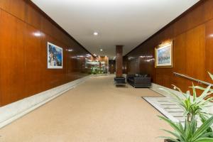 korytarz budynku z krzesłami i stołami w obiekcie APART CityMar 24h w mieście Vigo