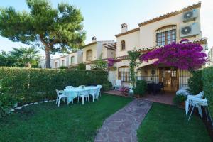 a house with a table and chairs in the yard at Mirall in Jávea