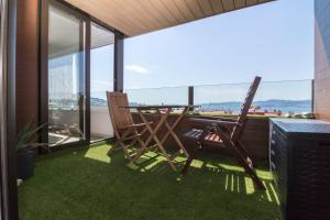 a patio with two chairs and a table on a balcony at APART CityMar 24h in Vigo