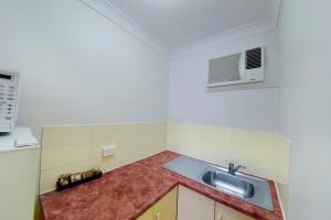 a kitchen with a sink and a microwave at Aspley Motor Inn in Brisbane