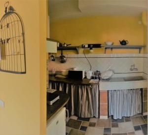 une cuisine avec une cage à oiseaux au mur dans l'établissement BED & BLU, à Savone