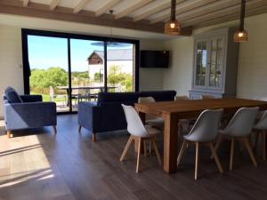 uma sala de estar com uma mesa de madeira e cadeiras em Villa Grande plage vue mer em Carnac