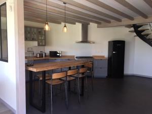 uma cozinha com uma mesa de madeira e algumas cadeiras em Villa Grande plage vue mer em Carnac