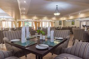 a dining room with a table and chairs at Sunbird Mzuzu in Katoto
