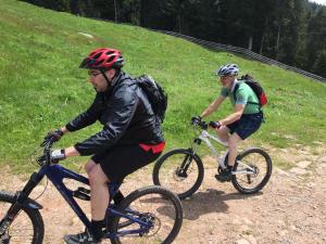 dois homens a andar de bicicleta numa estrada de terra batida em Oberfahrerhof em San Genesio Atesino