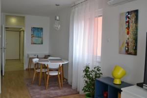 a living room with a table and chairs and a window at Fly Inn in Velika Gorica