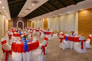 a banquet hall with red and white tables and chairs at Rio Boutique in Candolim +49 photos