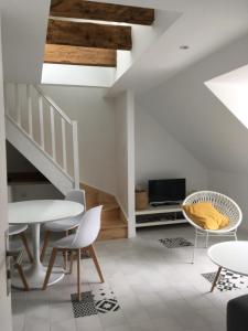 ein Wohnzimmer mit einer Treppe, einem Tisch und Stühlen in der Unterkunft LA VILLE A LA MER N°3 in Concarneau