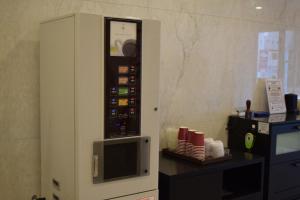 a vending machine with a microwave next to a table at Asakusa Central Hotel in Tokyo