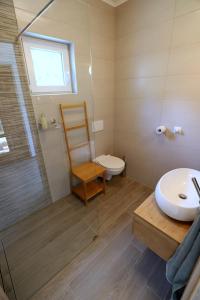 a bathroom with a toilet and a sink and a shower at Adventure Cottage with pool and big garden in Bled