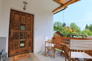 una camera con porta in legno, tavolo e sedie di Adventure Cottage with pool and big garden a Bled