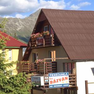 a house with a sign in front of it at Cabana la Razvan in Petroşani
