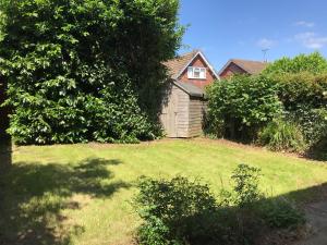 ヘレフォードにあるHereford - Raven House - 4 Bedroom House Located West Of City, Sleeps 7 - Perfect For Contractors Or a Base For Exploring - Hosted By RENTMYHOUSEの緑の芝生のある庭の小屋