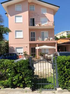 Um edifício cor-de-rosa com um portão à frente. em Villa Linda Affittacamere em Bellaria-Igea Marina