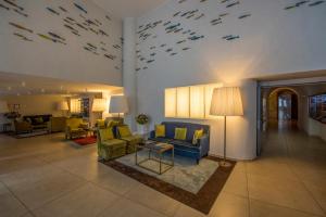 a living room with couches and chairs and a fish wall at Grand Hotel Portovenere in Portovenere