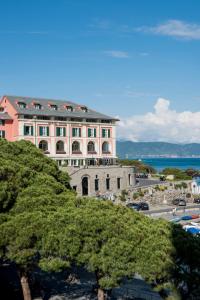 a large pink building with trees in front of it at Grand Hotel Portovenere in Portovenere