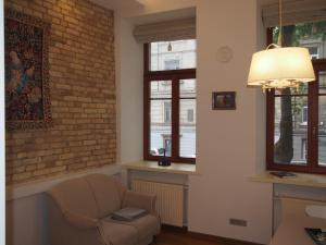 un soggiorno con sedia e muro di mattoni di Teatro Apartments a Vilnius