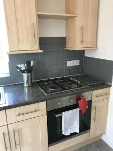 a kitchen with a stove with a towel on the oven at Raven House by RentMyHouse in Hereford