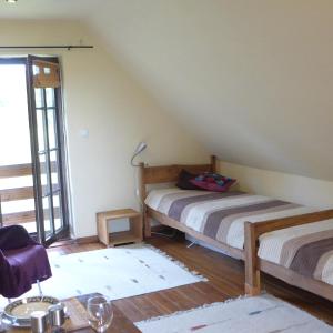 a room with two beds in a attic at Dom na Krańcu Świata in Łapicze