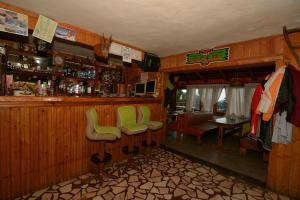 a bar with green chairs in a room at Cabana la Razvan in Petroşani