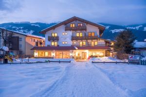 ein großes Haus im Schnee in der Nacht in der Unterkunft Loipenstubn in Brixen im Thale