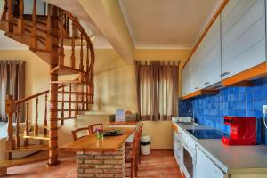a kitchen with a spiral staircase and a table at Bella Vista Villas & Suites in Gaios