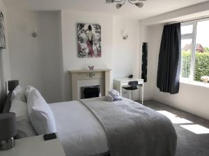 a white bedroom with a bed and a fireplace at Raven House by RentMyHouse in Hereford