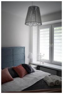 a bedroom with a large bed and a chandelier at Color24 Apartament in Stalowa Wola
