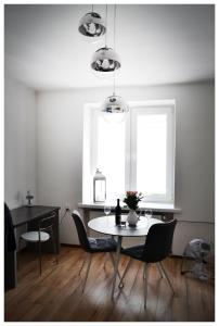 a dining room with a table and chairs and a window at Color24 Apartament in Stalowa Wola