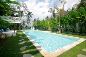 a swimming pool in the yard of a villa at The Apartments Ubud in Ubud