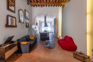 a living room with a couch and a red chair at Casatorre dei Leoni Dimora Storica in Siena