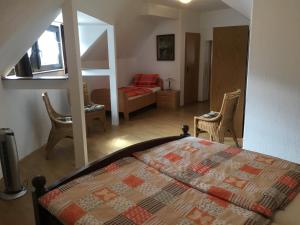 a bedroom with a bed and a living room at Geary Ferienwohnung in Klotten