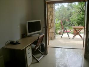 a room with a desk with a television and a sliding glass door at Villa Splendissima Krk - Adults only in Krk