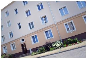 a large white building with flowers in front of it at Color24 Apartament in Stalowa Wola