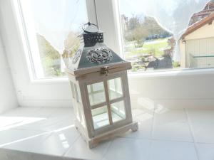 a lantern sitting on a floor in front of a window at Studio Manon in Portieux