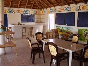 Cap Marniane في Mar Lodj: غرفة معيشة مع طاولات وكراسي ومطبخ