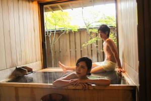 a boy and a girl sitting in a bath tub at Ichikawa Bekkan Seikanso in Shibukawa