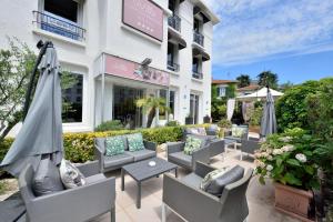 a patio with chairs and umbrellas in front of a building at Hôtel La Villa Cannes in Cannes