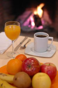 a plate of fruit with a cup of coffee and a glass of orange juice at La Casa del Cubón in Aguilafuente +33 photos