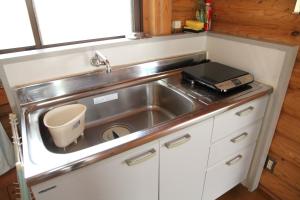 a small kitchen with a sink and a counter at 美濃田の淵キャンプ村 in Higashimiyoshi