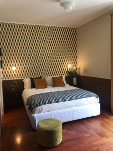 sypialnia z dużym łóżkiem i zielonym stołkiem w obiekcie Zebra Naviglio w Mediolanie
