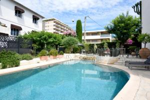 a swimming pool in front of a building at Hôtel La Villa Cannes in Cannes