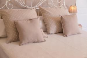 uma cama com quatro almofadas e uma cabeceira branca em Frasteva em Aci Castello