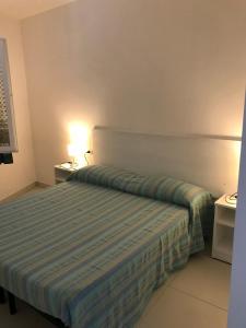 a bedroom with a bed with a blue striped comforter at villetta sul mare Rachele in Marina di Campo