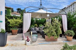 an umbrella on a patio with potted plants at Hôtel La Villa Cannes in Cannes