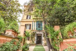 an old house with a green lawn in front of it at Rome Garden Hotel in Rome