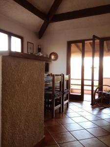 Zimmer mit einer Küche mit einem Tisch und Fenstern in der Unterkunft Casa fronte mare a La Maddalena in La Maddalena